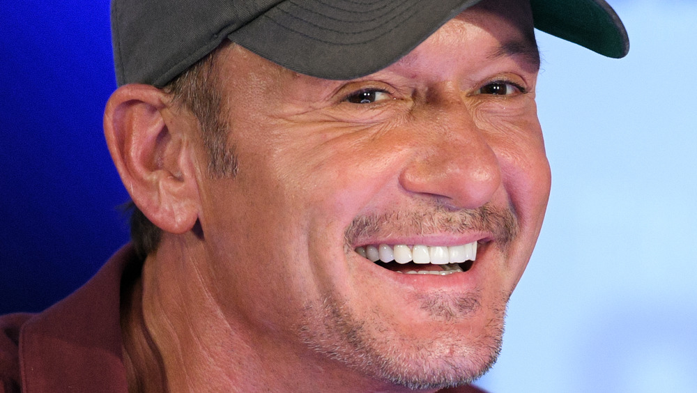 Tim McGraw wears a hat and smiles