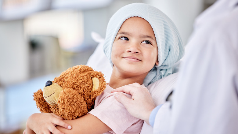 A child with cancer hugging a toy