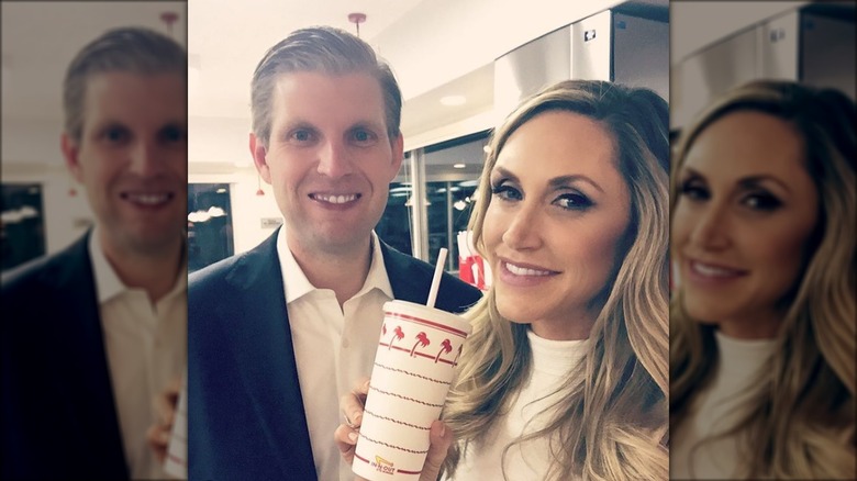 Eric and Lara Trump smiling with a cup