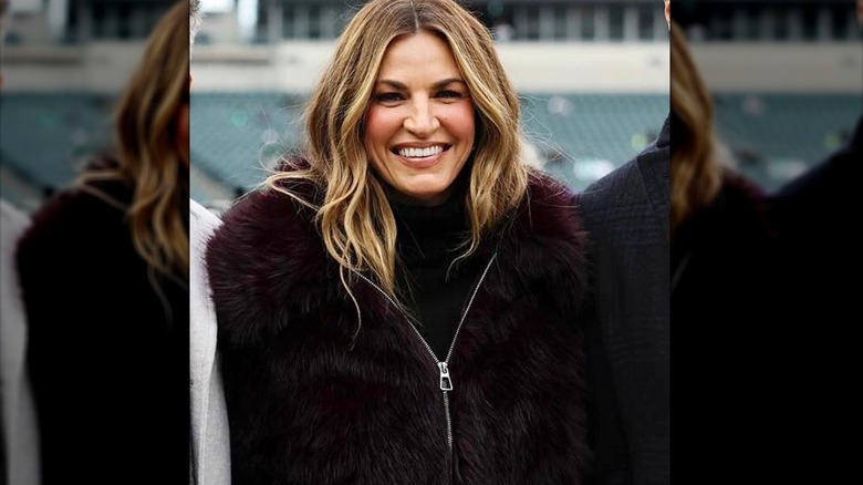 Erin Andrews smiling in purple fur coat