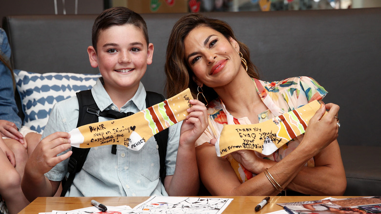 Eva Mendes posing for photos with a child