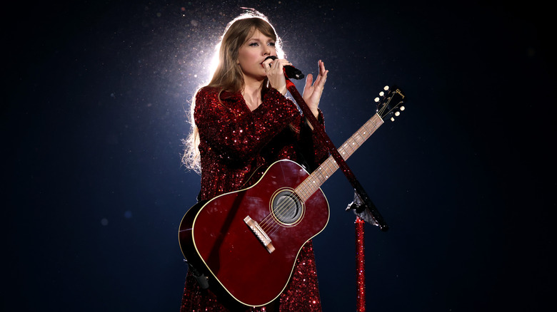 Taylor Swift singing on stage with guitar