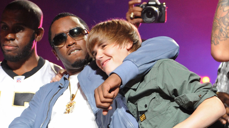 Diddy hugging Justin Bieber while they perform together onstage