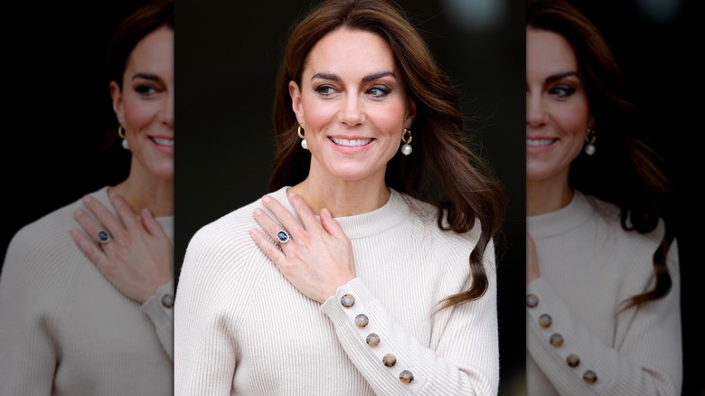 Kate Middleton smiling smiling with hand on shoulder