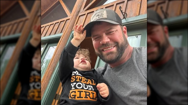 Jayson Boebert holding his grandson, as the toddler touches Jayson's hat.