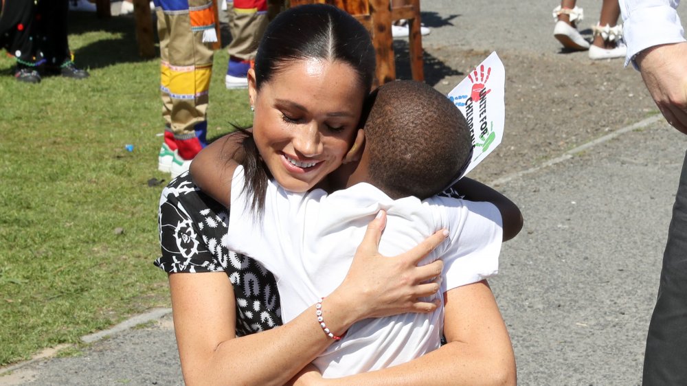 Meghan Markle hugging a little boy in Africa