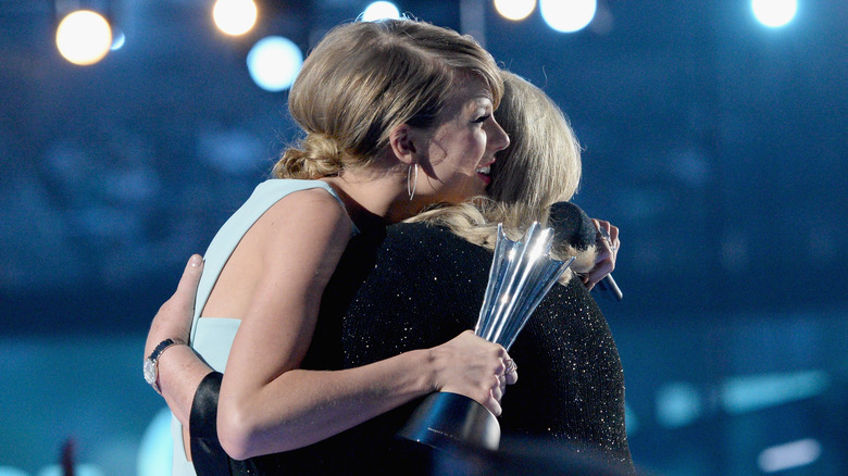 Taylor Swift and Andrea Swift embracing on stage in 2015