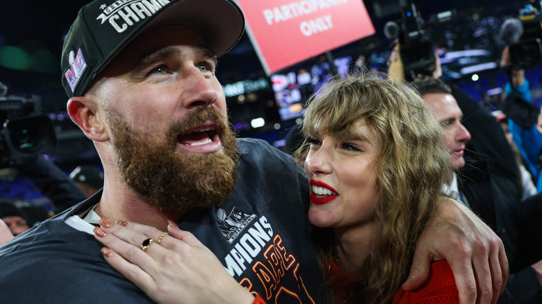 Travis Kelce and Taylor Swift side-hugging after a football game