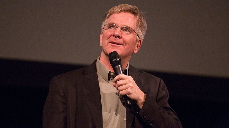 Rick Steves speaking into a microphone in 2013