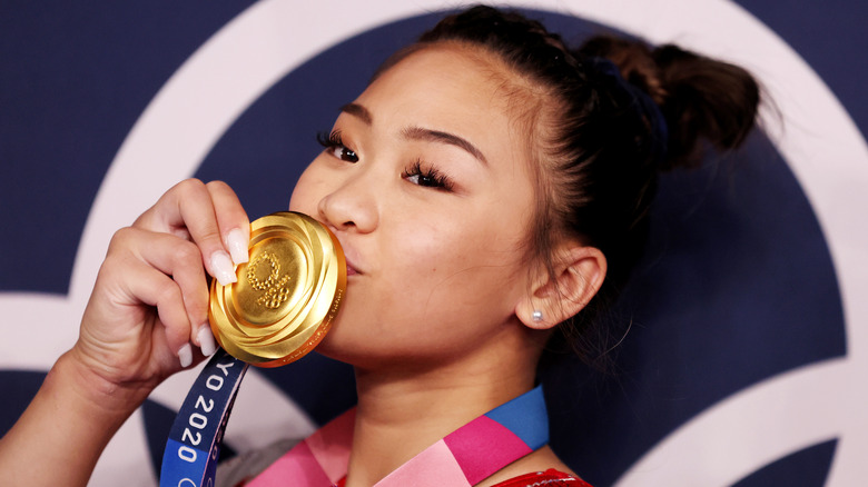 Suni Lee kissing her gold medal 