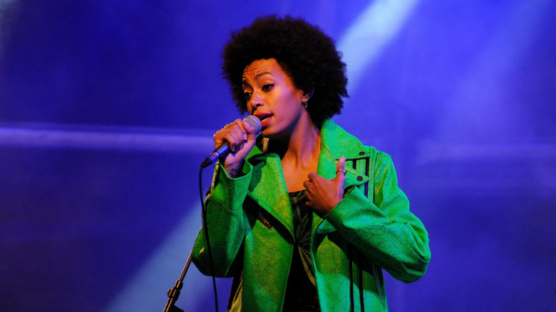 Solange Knowles sings into a microphone