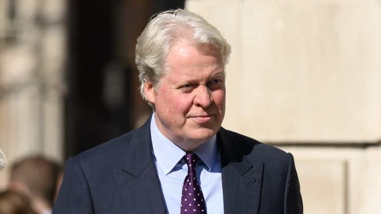 Charles Spencer outside, in a suit and time, looking away from the camera