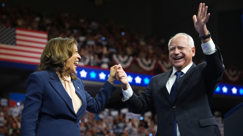 Tim Walz smiling onstage with Kamala Harris