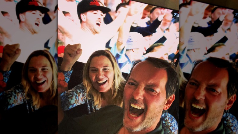 Kim Cattrall and Russell Thomas cheering and watching sports