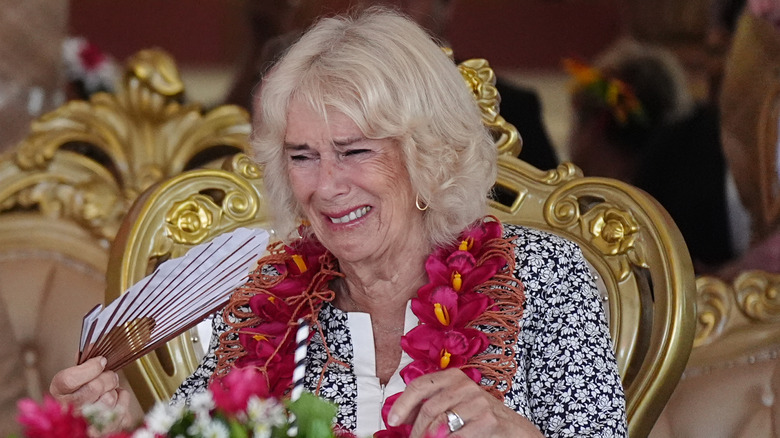 Queen Camilla crying while holding fan