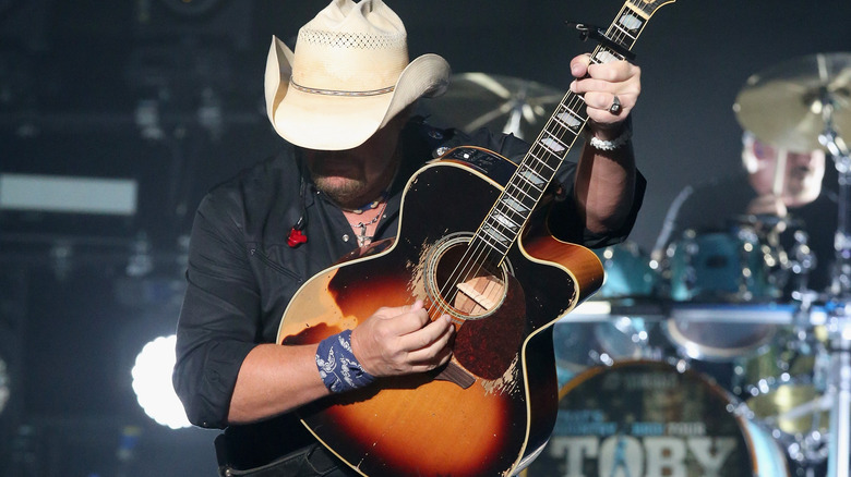 Toby Keith with head down, playing the guitar