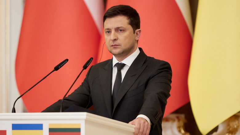 Volodymyr Zelenskyy standing at podium 