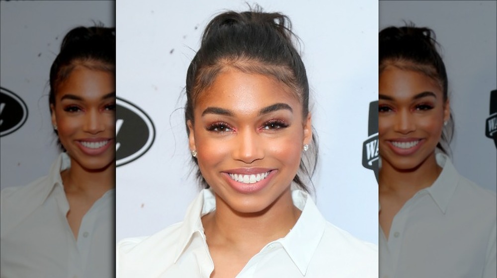 Lori Harvey in a white shirt, smiling