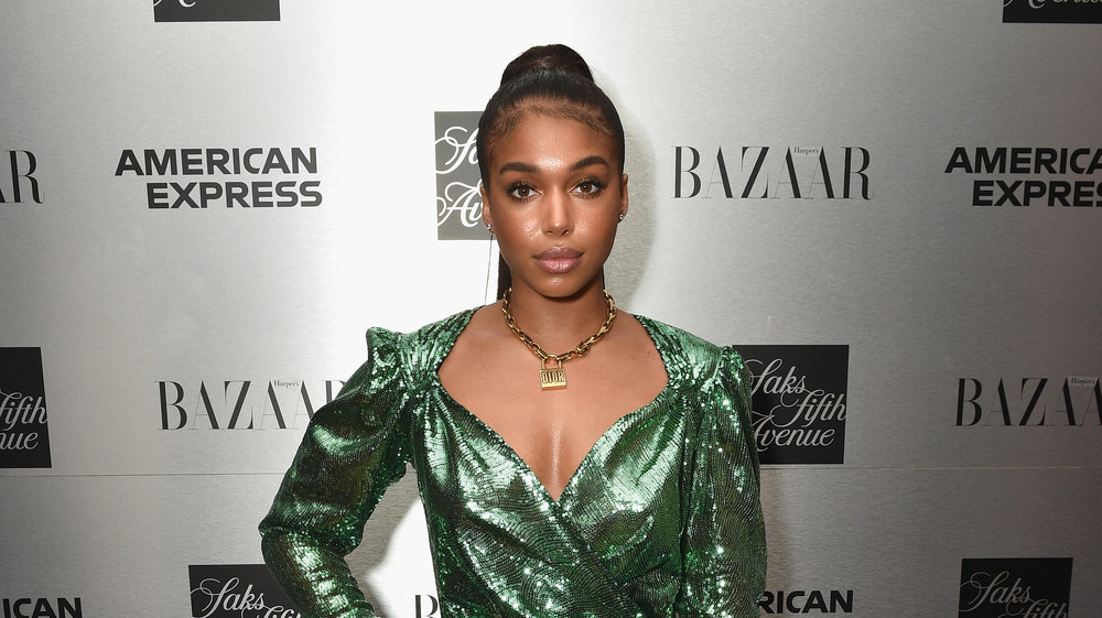 Lori Harvey  wearing a green sequined dress