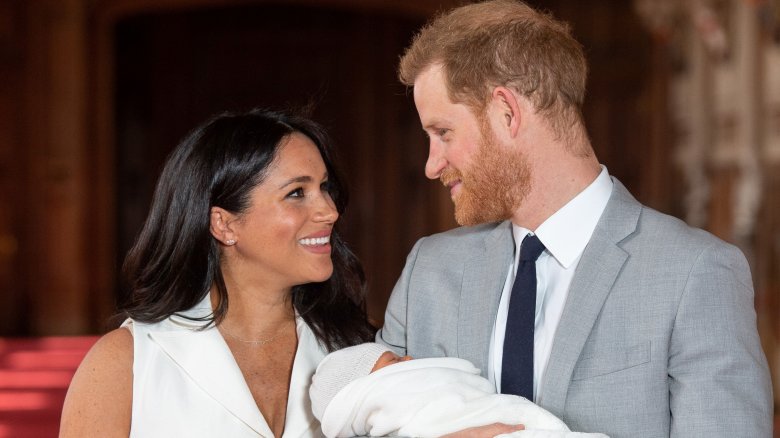 Meghan and Harry smiling at each other with baby