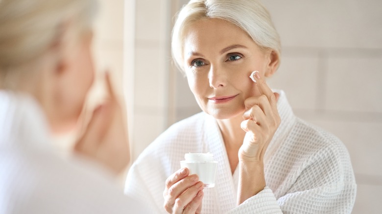 Older woman applying skincare product