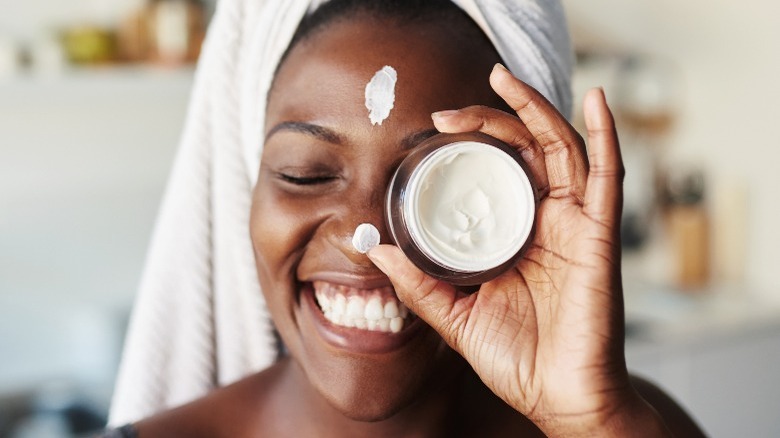 Woman holding tea tree oil moisturizer