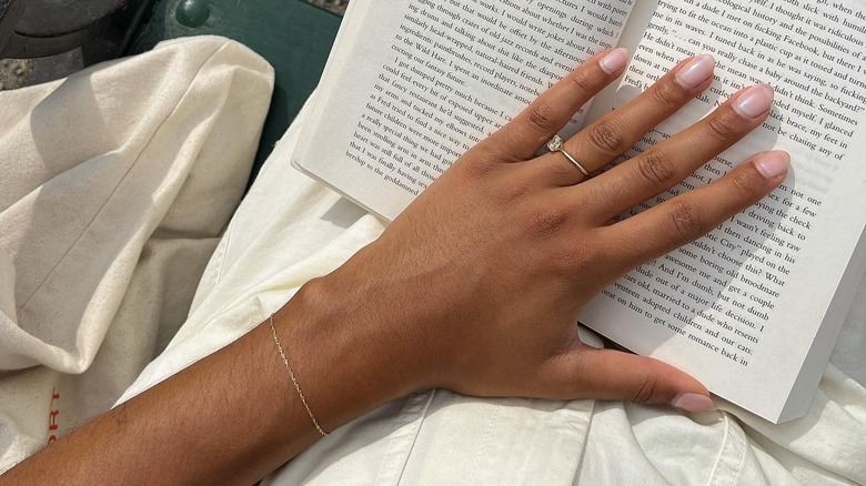 Person with a permanent bracelet holding a book