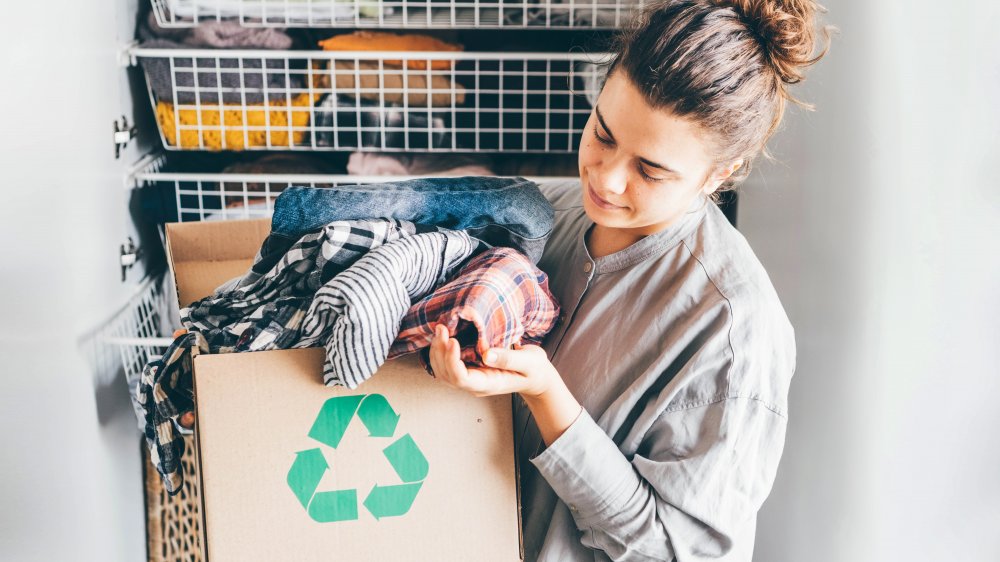 Woman donating old clothes, like ones H&M would accept