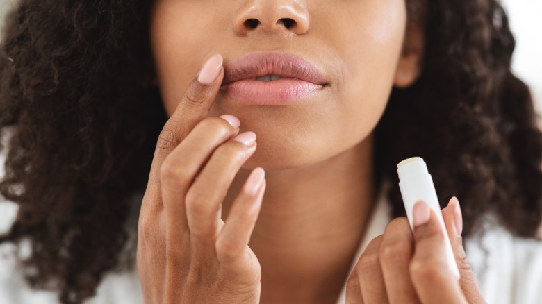 Woman applying lip balm