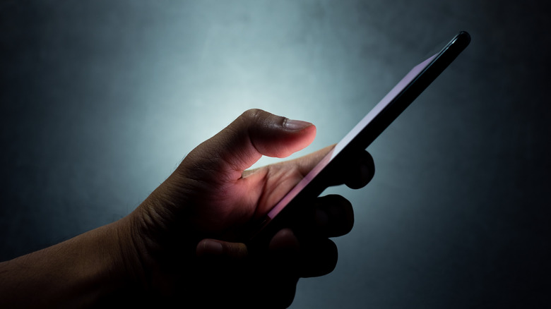 hand holding a cell phone in the dark