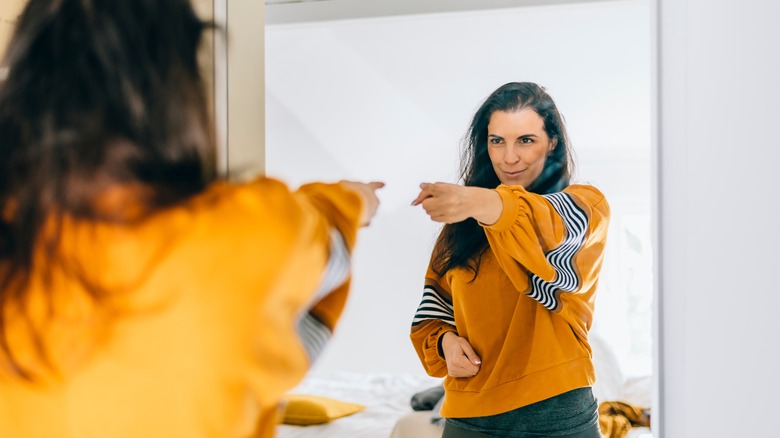 Woman pointing at mirror