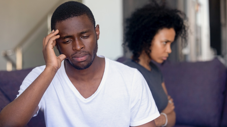 Frustrated couple sitting on couch