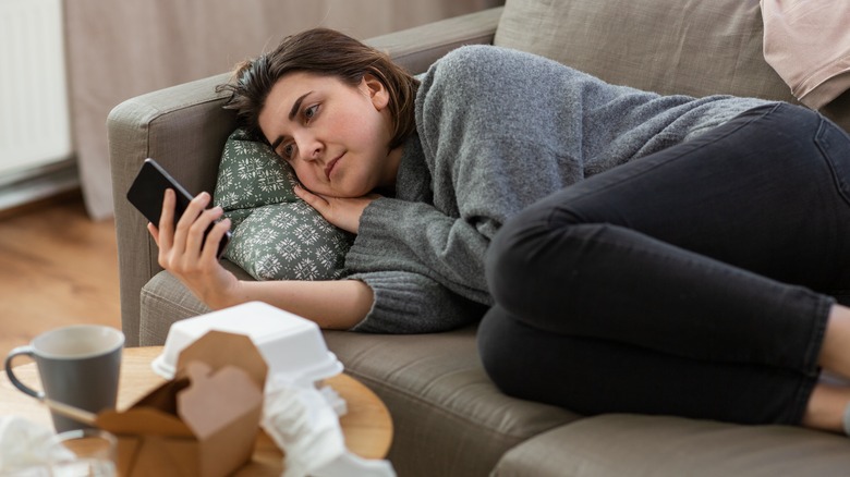 woman scrolling social on couch