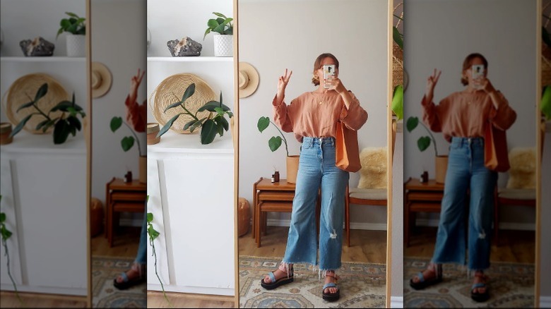 Woman doing peace sign in mirror