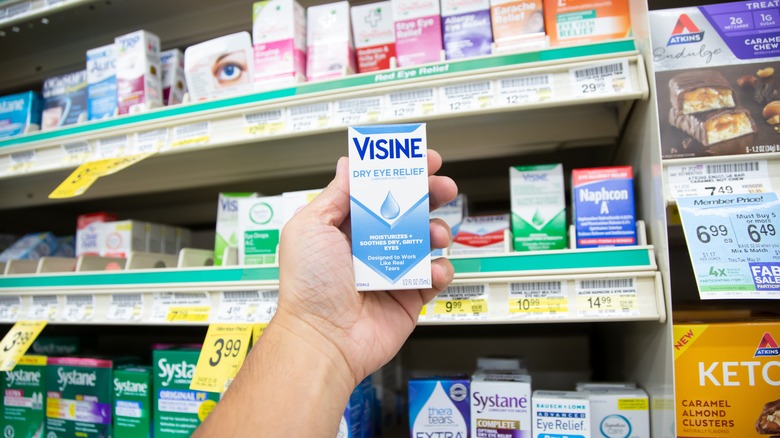 person holding Visine eye drops box