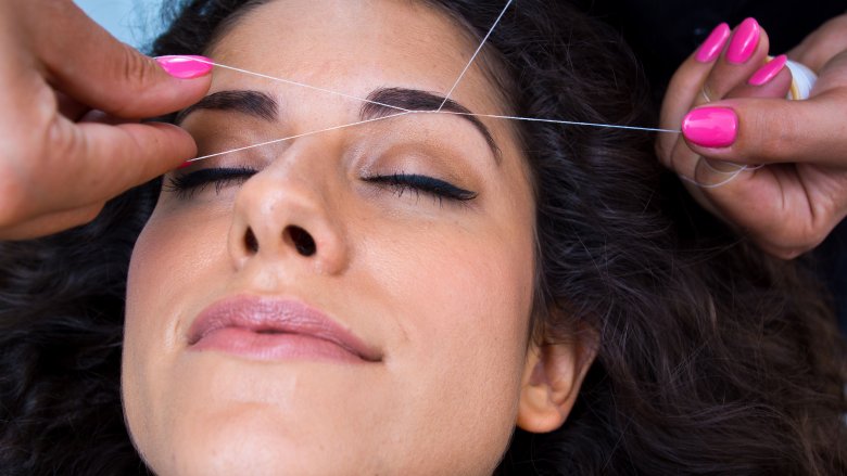 woman having eyebrows threaded