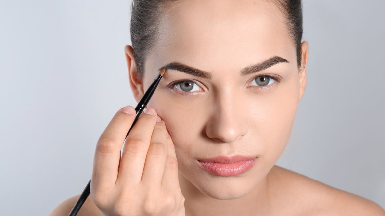 woman shaping eyebrows