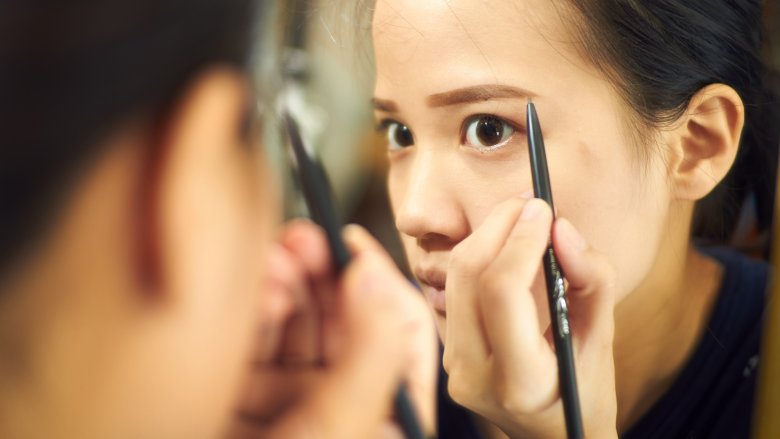 woman filling in eyebrows