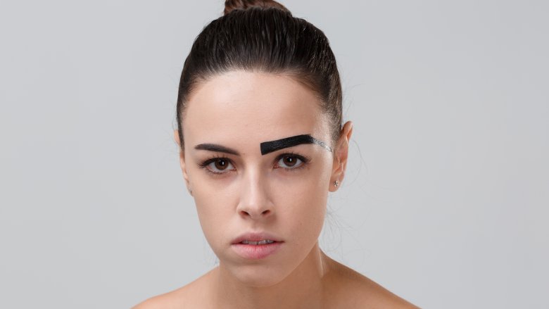 woman with one painted eyebrow