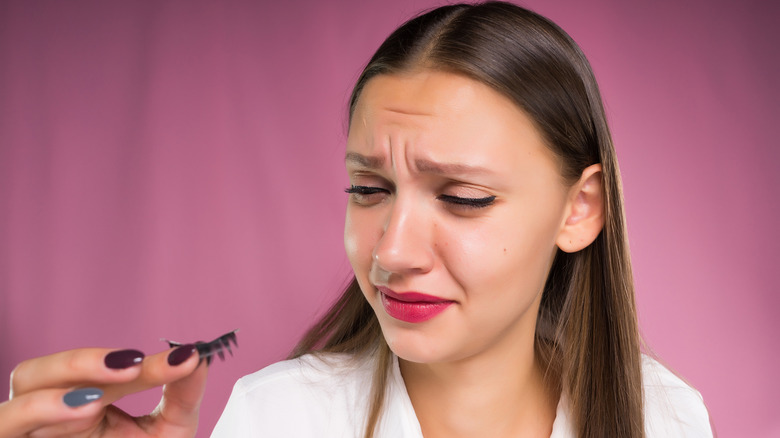 woman taking off false lashes