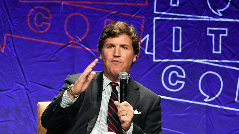 Tucker Carlson speaking into mic