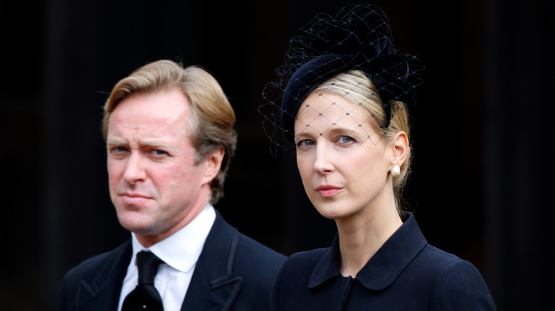 Thomas Kingston and Lady Gabriella looking at camera in funeral attire