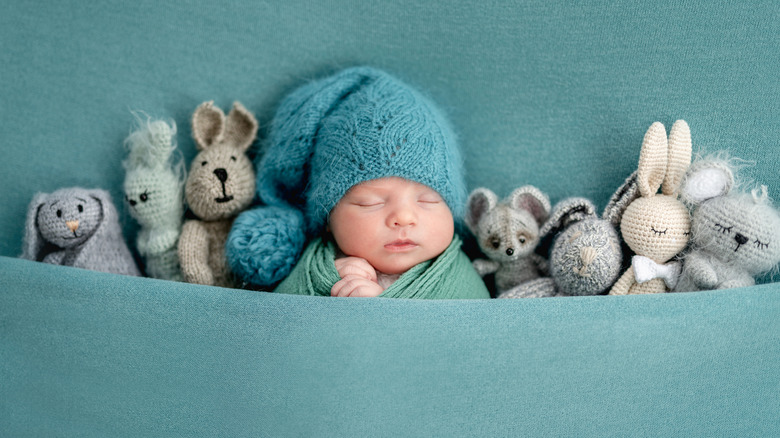 newborn baby sleeping with stuffed animals