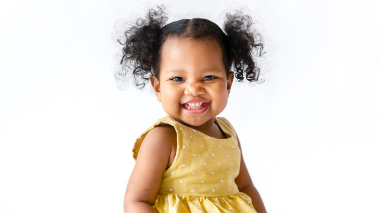 cheerful toddler in yellow dress