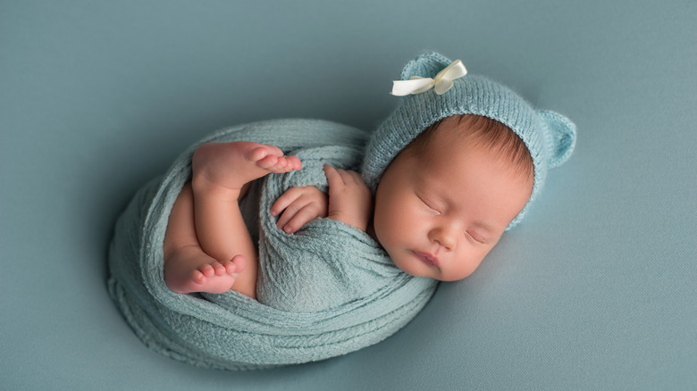 newborn baby sleeping in blue hat