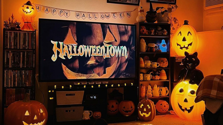 living room decorated for halloween, with halloweentown on the tv