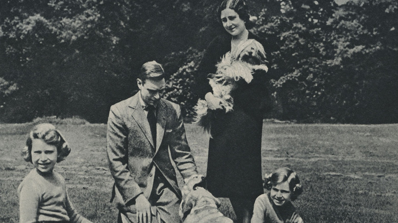 Princess Elizabeth, King George VI, Queen Consort Elizabeth, and Princess Margaret playing with pets