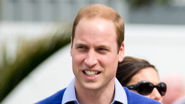 Prince William smiling but looking away from camera