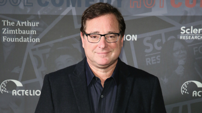 Bob Saget poses for a photo at an event. 