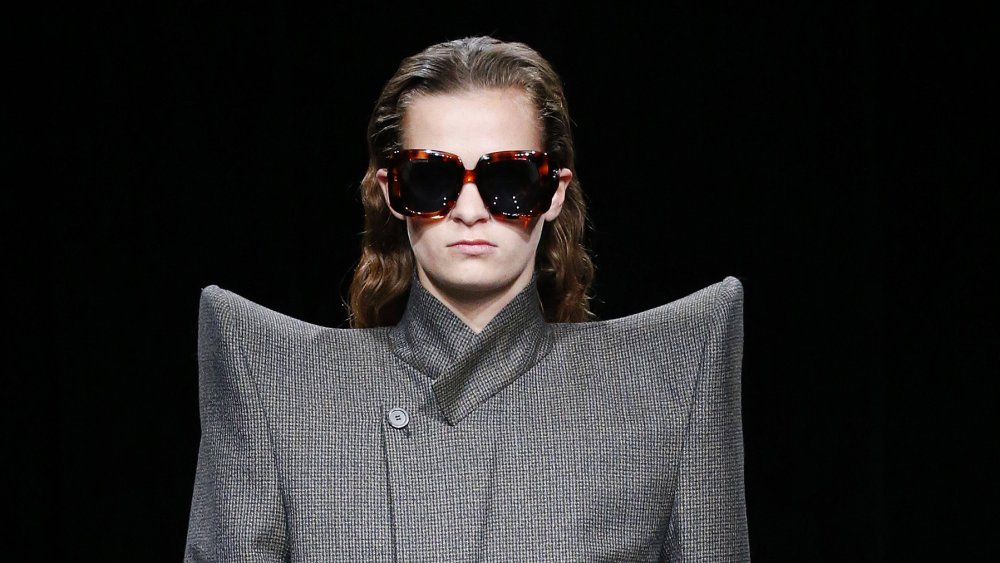 A woman at Fashion Week wearing dramatic shoulders